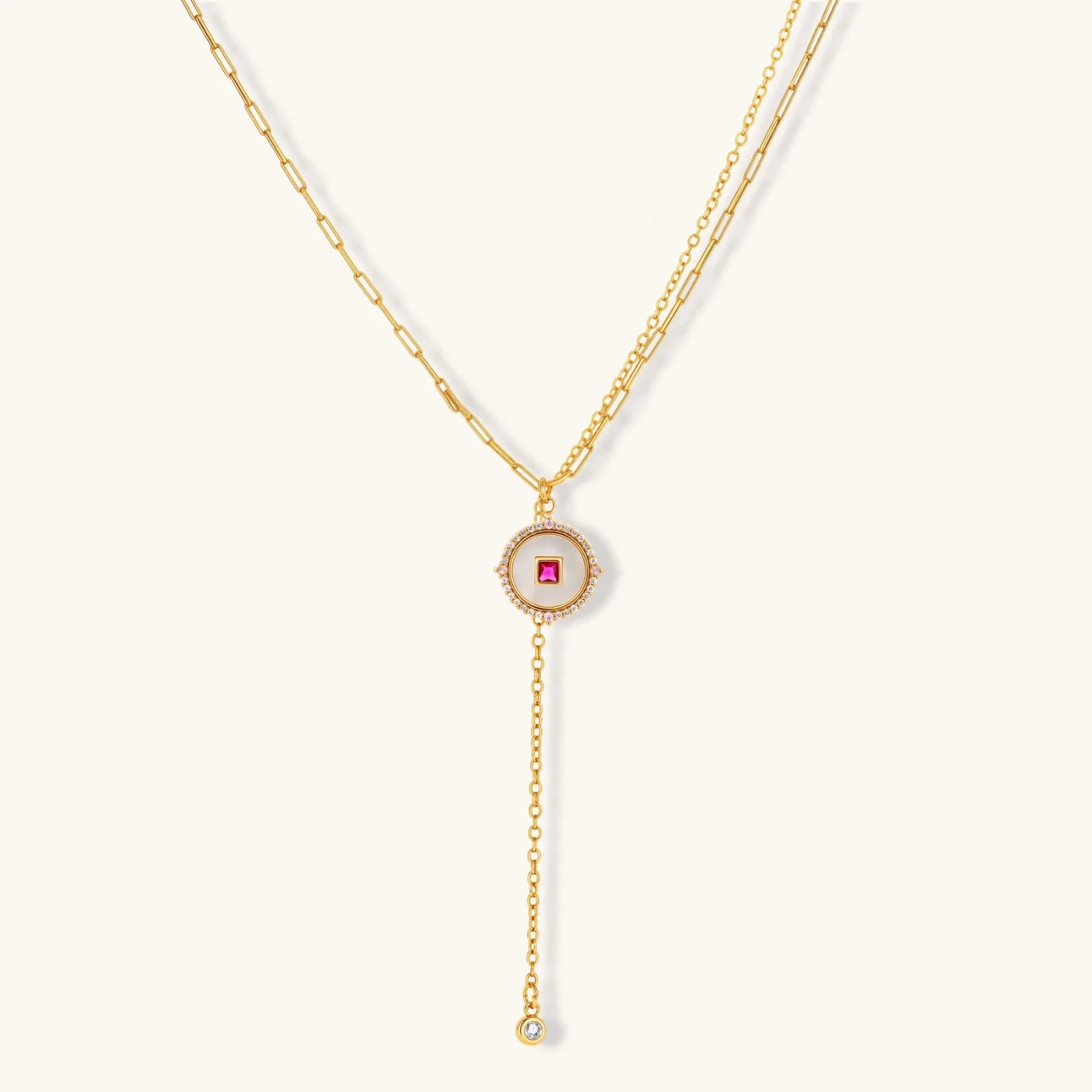 Gold-plated circular medallion necklace set with white enamel base and pink cubic zirconia accent stones